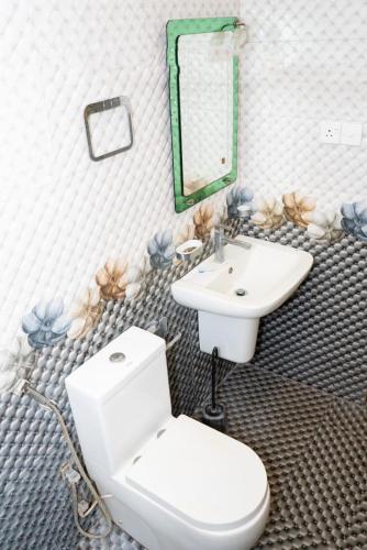 a bathroom with a white toilet and a sink at Kanapathiy Rest House in Trincomalee