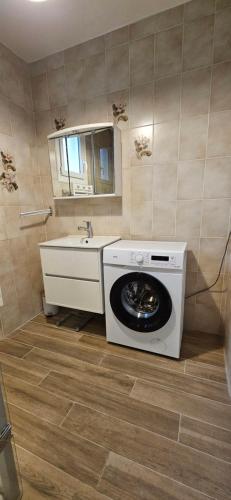 a washing machine in a bathroom with a sink at La Maison Bricquebetaise in Bricquebec