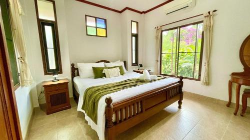 ein Schlafzimmer mit einem großen Bett und einem Fenster in der Unterkunft Villa Mona-Beachfront Sunset Peaceful Garden Villa in Nathon Bay