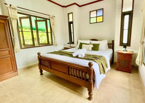 ein Schlafzimmer mit einem großen Bett und einem Fenster in der Unterkunft Villa Mona-Beachfront Sunset Peaceful Garden Villa in Nathon Bay