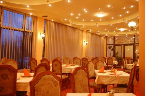 a restaurant with tables and chairs in a room at Hotel Everest in Târgu-Mureş