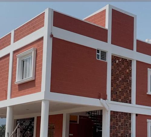 a building with red and white at Krishnagudi Temple Stay in Coimbatore