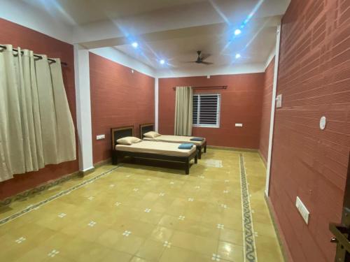a room with a bed in a room with red walls at Krishnagudi Temple Stay in Coimbatore