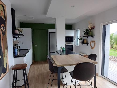 Il comprend une cuisine avec une table et des chaises en bois. dans l'établissement Ty Nez, Séjour Cosy, à Riec-sur-Bélon