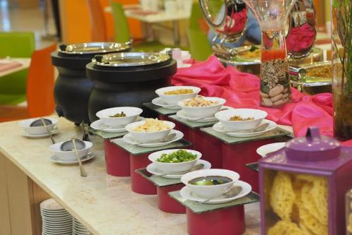 a buffet with bowls of food on a table at favehotel Manahan - Solo in Solo