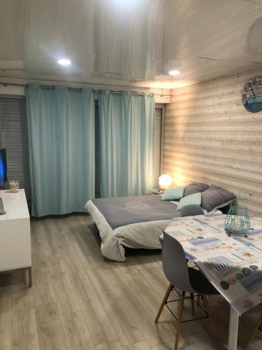 - une chambre avec 2 lits et une table avec des chaises dans l'établissement Studio face Mer, à Saint-Jean-de-Monts