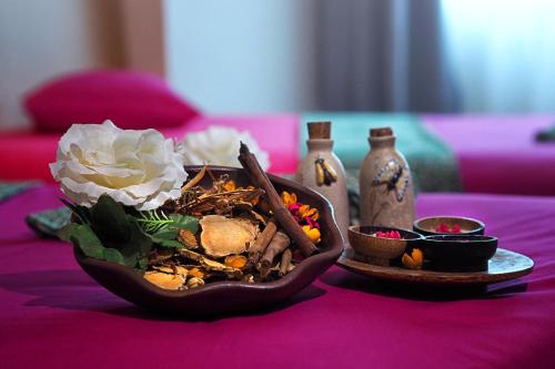 a bowl of food on a table with a flower at favehotel Manahan - Solo in Solo