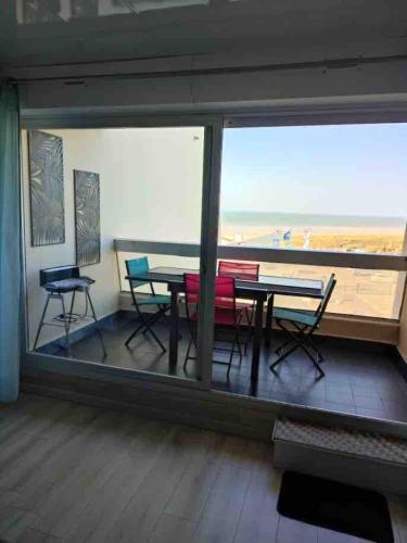 un balcon avec une table et des chaises et une vue sur la plage dans l'établissement Studio face Mer, à Saint-Jean-de-Monts