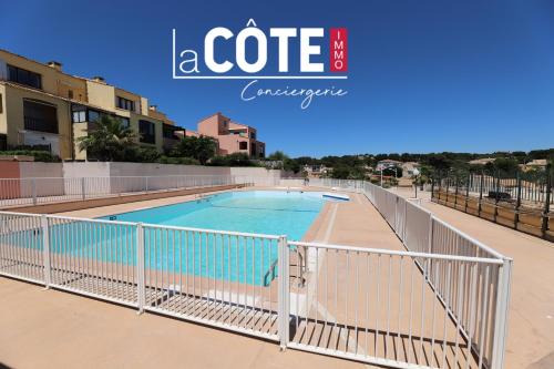 une porte autour d'une piscine dans un immeuble dans l'établissement Le Madura, à Sausset-les-Pins