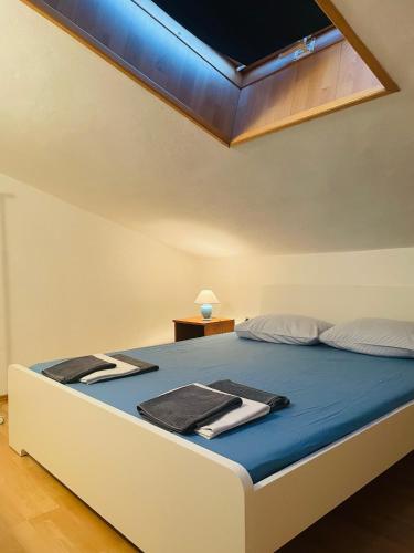 a bedroom with a bed with blue sheets and a ceiling at Apartments Vozab in Pag