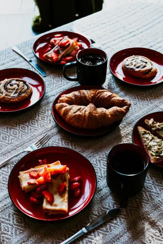 a table with red plates of food and a pie at Koka namiņš "Pasaka" in Vecumnieki
