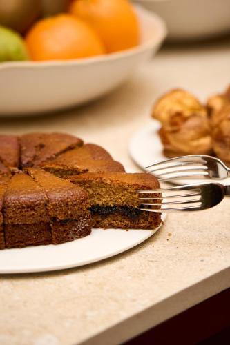 a piece of cake on a plate with a fork at Hostellerie Du Chapeau Rouge in Dijon