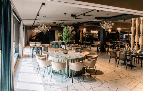 a dining room with tables and chairs and chandeliers at Hotel 3 Trio in Białystok