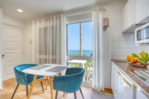 kuchnia ze stołem i krzesłami z widokiem na ocean w obiekcie Quinta da Vila w mieście Porto da Cruz