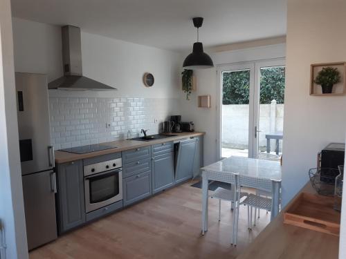une cuisine avec des appareils en acier inoxydable et une table dans l'établissement Ty Glaz, à Carantec