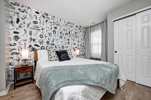 a bedroom with a bed with a black and white wallpaper at 5 min to Grand Park, 1Level, Stocked Kitchen, King Bed, GameRm, Firepit, BBQ, Pet Friendly in Westfield