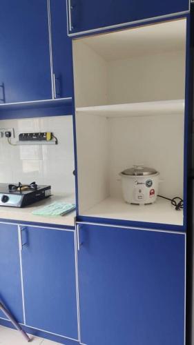 a kitchen with blue cabinets and a appliance in it at Homestay Afiqah in Melaka