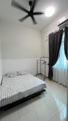 a bedroom with a bed and a ceiling fan at Homestay Afiqah in Melaka