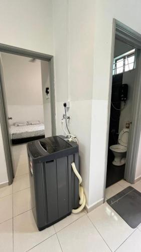 a bathroom with a trash can and a toilet at Homestay Afiqah in Melaka
