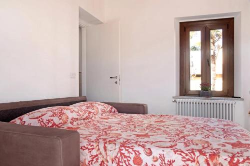 a bedroom with a bed with a red and white blanket at Casa Andrea e Linda in Germignaga