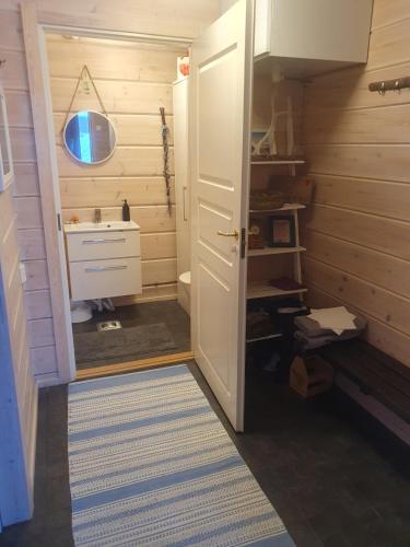 a small bathroom with a sink and a mirror at Uiton kotirantasauna in Kiemunkivaara