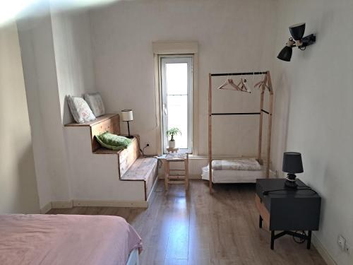 - une chambre avec un lit et un escalier menant à une fenêtre dans l'établissement Triplex cosy, à Lyon