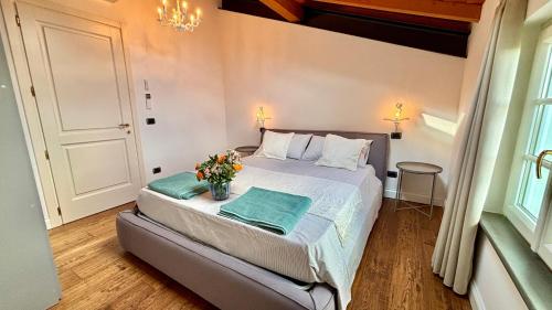 a bedroom with a bed with a vase of flowers on it at Villa Laitona in Quinto di Valpantena
