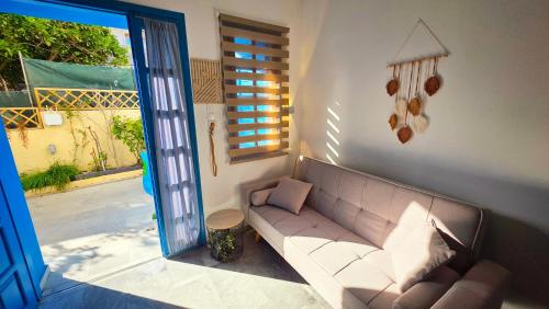 a living room with a couch and a window at Michele Marie apts in Agia Pelagia