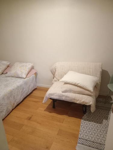 - une chambre avec un lit, un canapé et du parquet dans l'établissement 2 pièces proche centre villes, à Paris