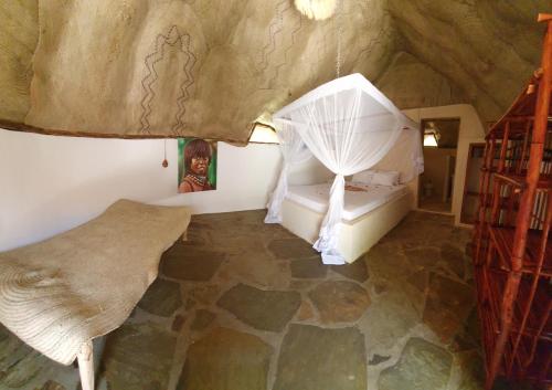 a bedroom with a bed in a cave style room at Kirepwe Ecco Camp Watamu in Watamu