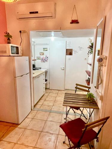 a kitchen with a refrigerator and a table and chairs at Dotan's Boutique Apartments - By The Beach! in Tel Aviv