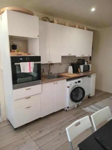 La cuisine est équipée de placards blancs, d'un évier et d'un lave-linge. dans l'établissement 2 pièces proche centre villes, à Paris