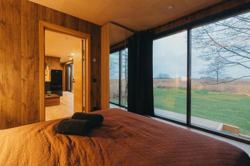 a bedroom with a large bed and a large window at Sunset Retreat in Ainaži