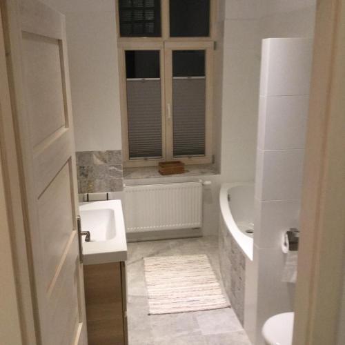 a bathroom with a sink and a tub and a window at Sopot Lodge in Sopot