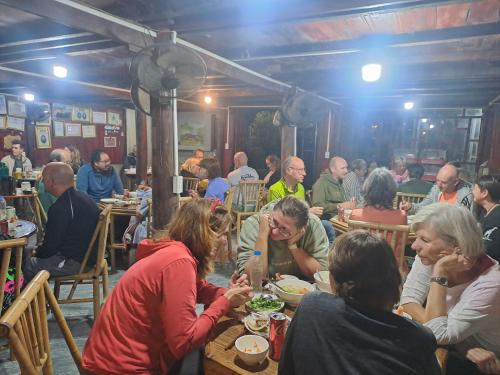 a group of people sitting at tables in a restaurant at Kim in Thổng Khào