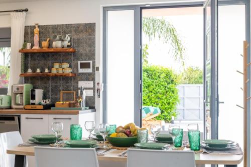 a kitchen with a table with plates and wine glasses at Antonakis Villa Rhodes Private Pool & Jacuzzi Retreat in Kremasti