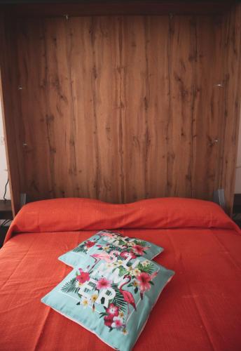 a red bed with a red comforter with at Casa Vacanze Cimorelli in Venafro