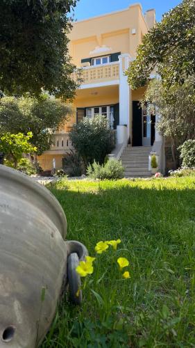 a house with a yard with yellow flowers in the grass at Villino Vanzetti 1930 in Cagliari
