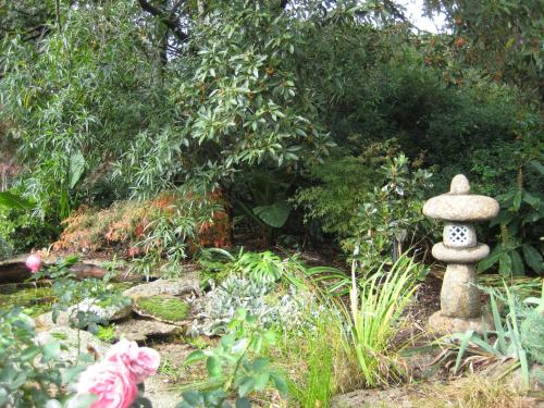 a garden with a stone statue in the middle at Bungunyah Apartments in Croydon