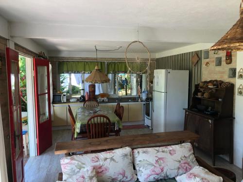 a kitchen and dining room with a table and a refrigerator at Recanto Praia do Forte - SC in São Francisco do Sul