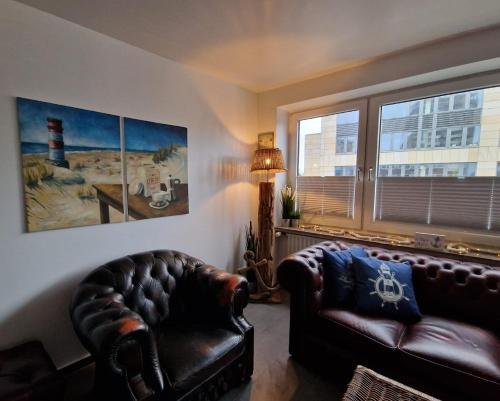 a living room with a leather couch and a window at Bremen City in Bremen