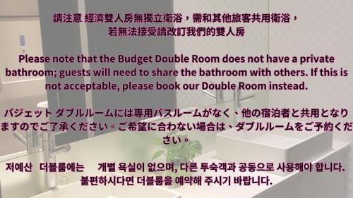 a sign that reads please note that the budget double room does not have a bathroom at Queens Hotel II in Taipei