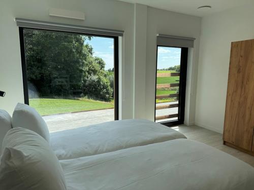 a bedroom with a bed and a large window at Vakantiewoning The View in Gooik