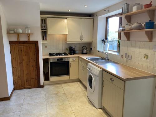 eine Küche mit Spüle und Geschirrspüler in der Unterkunft Little Cottage - A Peaceful 3BD Retreat for 5 in Chorley