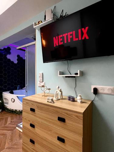 une télévision sur un mur au-dessus d'une commode en bois dans l'établissement GI-AZ f, à Bondy