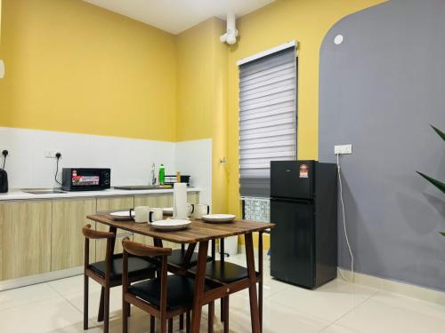 a kitchen with a wooden table and a black refrigerator at Core Soho Suites Kota Warisan Sepang KLIA Airport Free Wifi by BKA LEGACY in Sepang