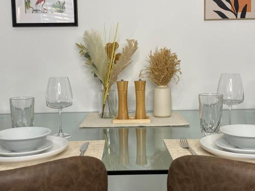 a glass table with plates and bowls and glasses at Town Centre Two-Bedroom in Swindon