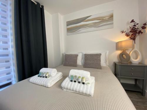 a bedroom with two beds with towels on them at Town Centre Two-Bedroom in Swindon