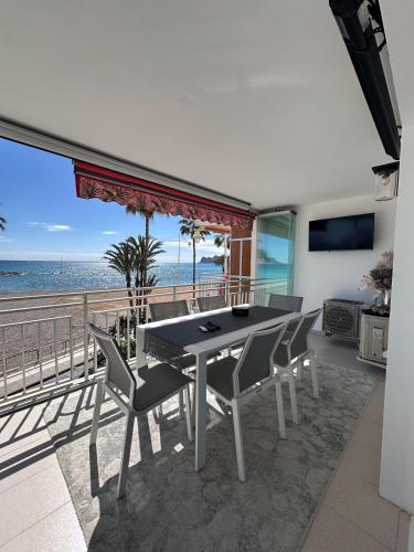 a dining room with a table and chairs and the beach at Altea Beach Apartment in Altea