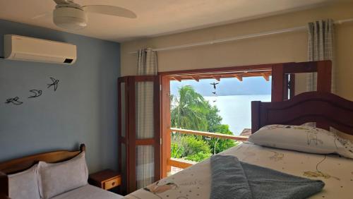 a bedroom with a bed and a view of the ocean at Suite Pássaros in Ilhabela